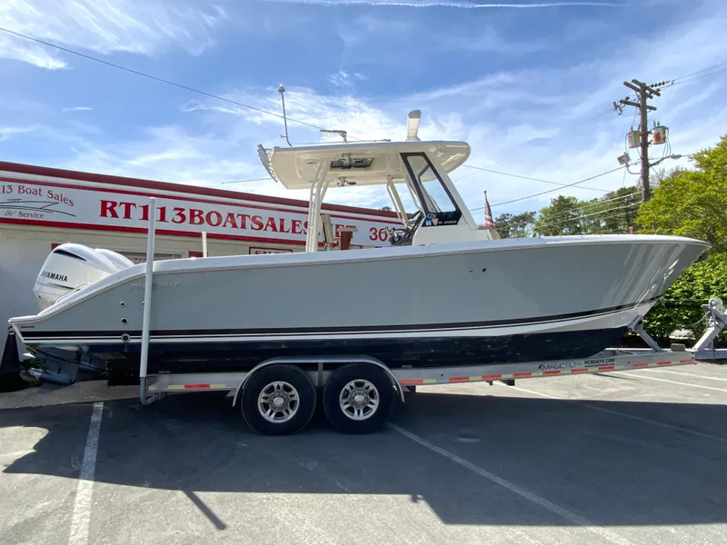 The Image of 2020 Pursuit S 288 Sport boat on trailer at dealership under clear sky. - 0