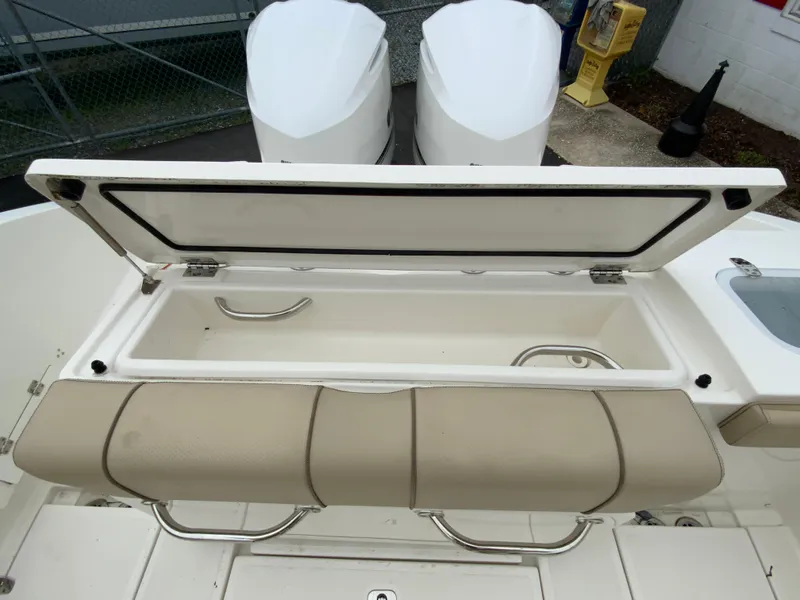 Slide: The Image of 2020 Pursuit S 288 Sport boat with open storage compartment and dual engines. - 14