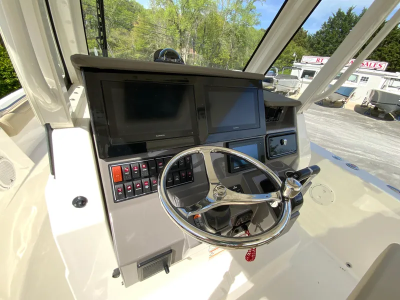Slide: The Image of 2020 Pursuit S 288 Sport boat dashboard with steering wheel and electronic displays. - 16