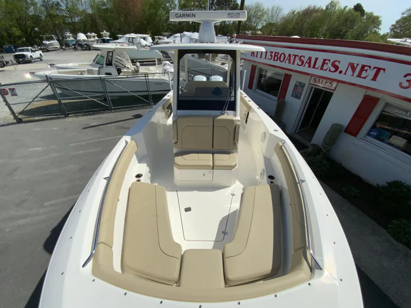 Slide: The Image of 2020 Pursuit S 288 Sport boat with tan seating, docked near a sales office. - 23