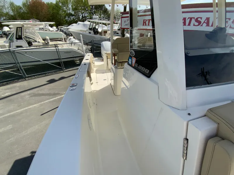 Slide: The Image of 2020 Pursuit S 288 Sport boat, sleek design, docked at marina with other vessels. - 27