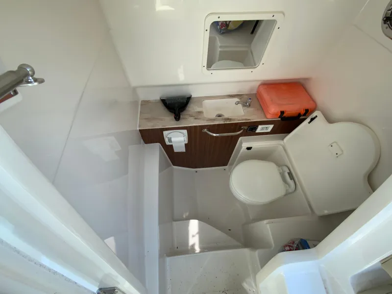 Slide: The Image of 2020 Pursuit S 288 Sport boat interior bathroom with toilet, sink, and storage. - 29