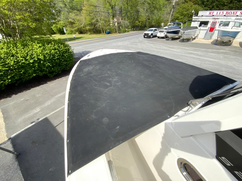 Slide: The Image of 2020 Pursuit S 288 Sport boat with black canvas cover, parked outdoors. - 32