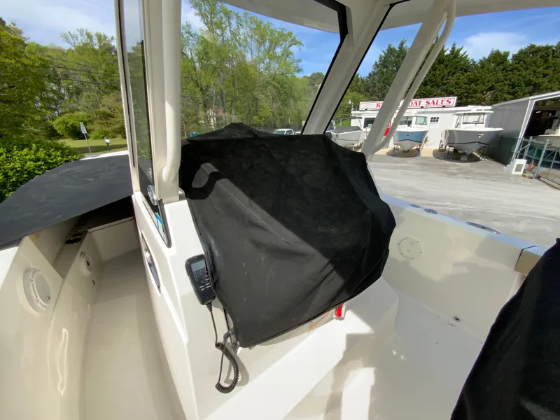 Slide: The Image of 2020 Pursuit S 288 Sport boat interior with covered console, outdoor setting. - 34