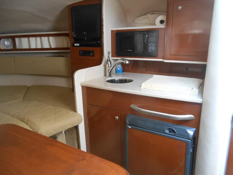 Slide: The Image of 2008 Sea Ray 280 Sundancer interior with kitchenette, sink, microwave, and cozy seating area. - 11