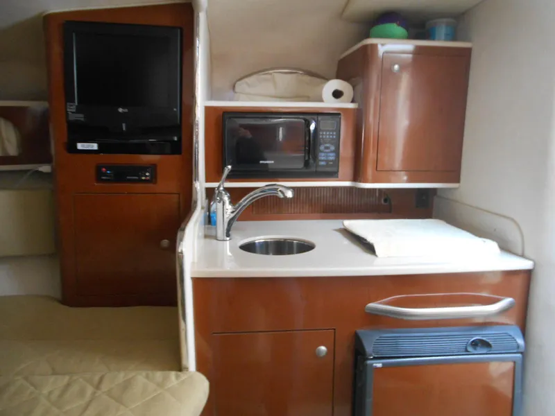 Slide: The Image of 2008 Sea Ray 280 Sundancer cabin with kitchenette, TV, microwave, and sink. - 12