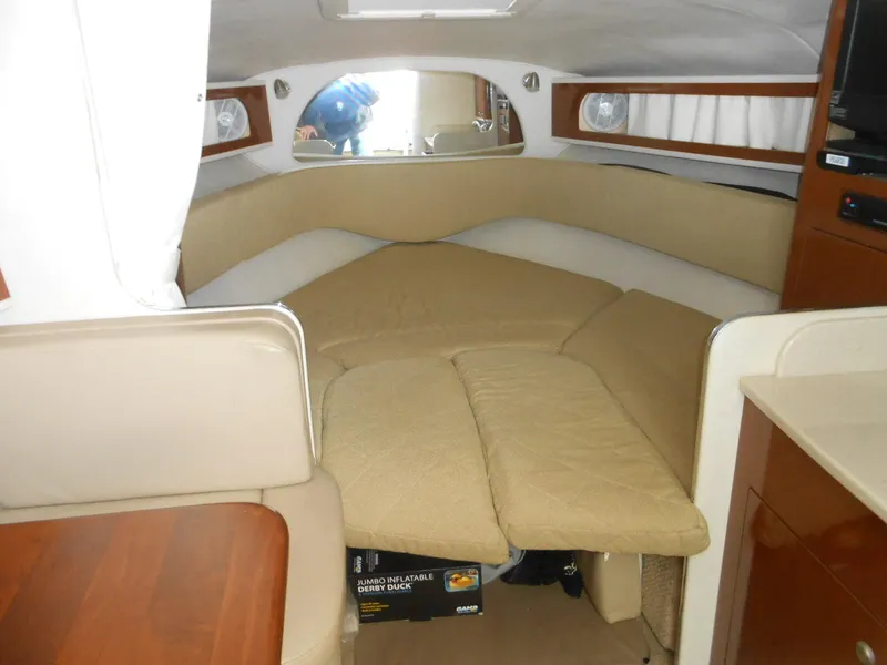 Slide: The Image of 2008 Sea Ray 280 Sundancer cabin interior with beige seating and wood accents. - 8