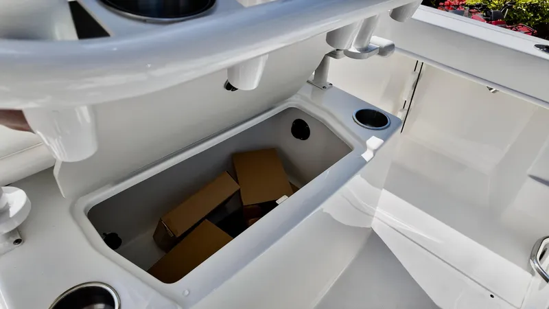 Slide: The Image of 2025 Bayliner Trophy 20 boat storage compartment with cup holders and boxes inside. - 2
