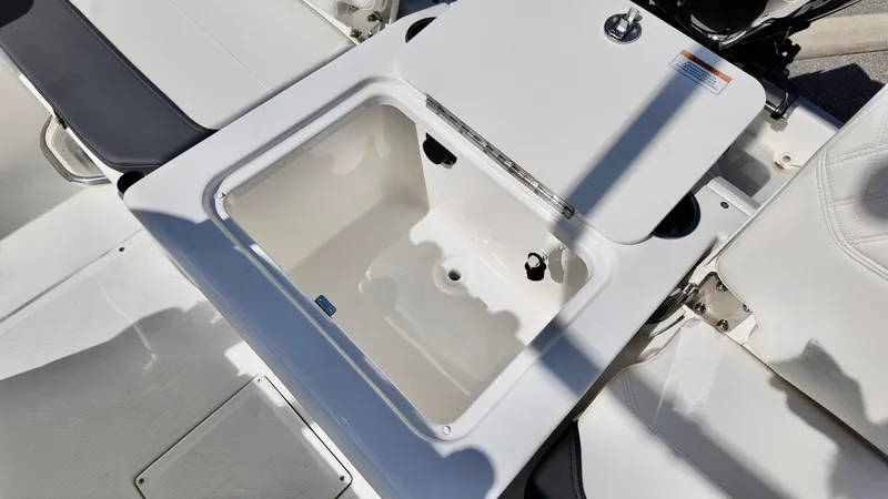 Slide: The Image of 2025 Bayliner Trophy 20 boat storage compartment, open lid, white interior, sleek design. - 4