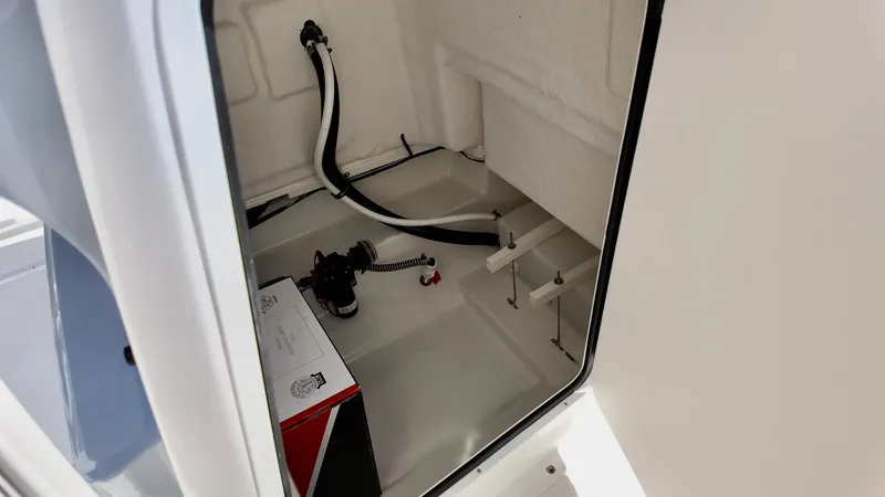 Slide: The Image of 2025 Bayliner Trophy 20 storage compartment with wiring and equipment. - 8