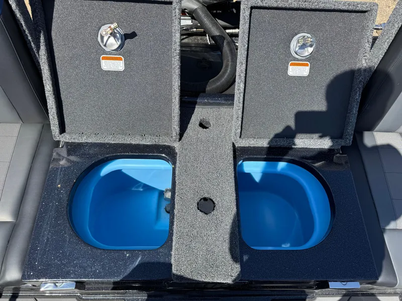 Slide: The Image of 2025 Nitro ZV20 Sport Pro boat livewell compartments with blue interior. - 6