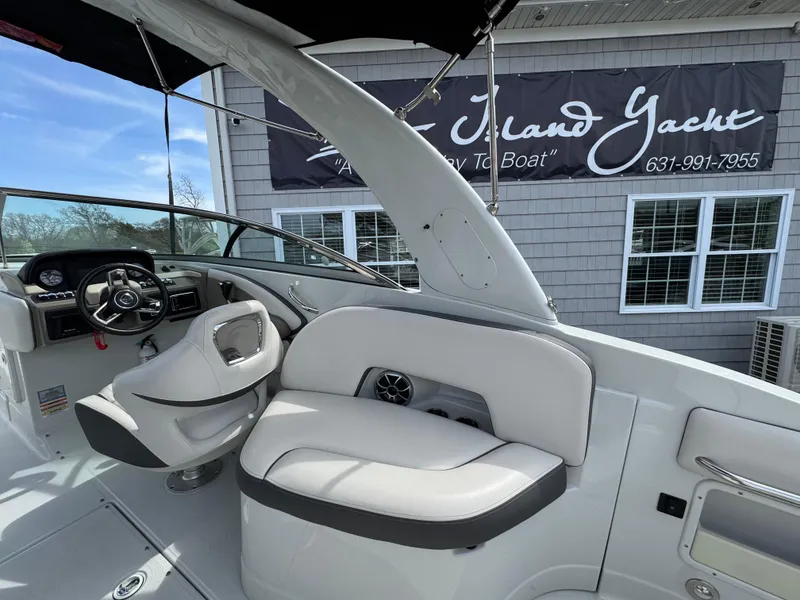 Slide: The Image of 2019 Crownline 290 XSS boat interior with steering wheel and seating area. - 14