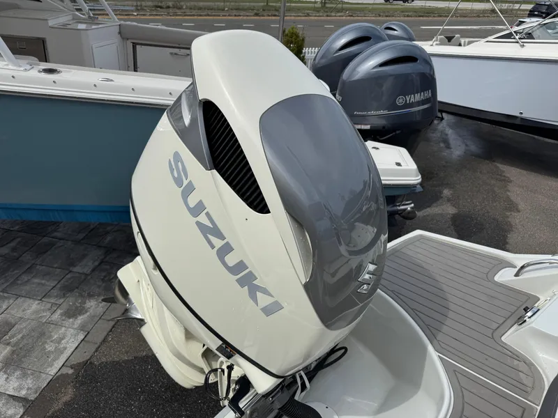 Slide: The Image of 2019 Crownline 290 XSS with Suzuki outboard motor, parked on a marina. - 18