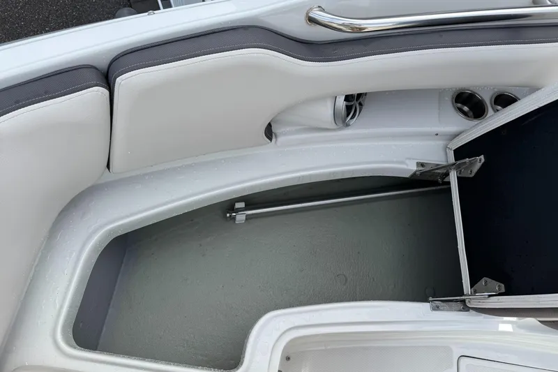 Slide: The Image of 2019 Crownline 290 XSS boat interior storage compartment with open hatch and seating area. - 4