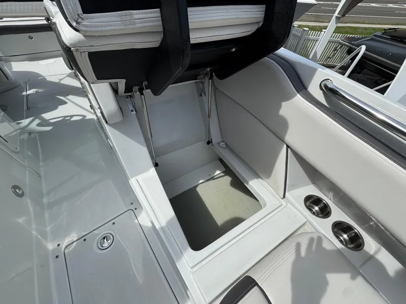 Slide: The Image of 2019 Crownline 290 XSS boat interior with storage compartment and cup holders. - 6