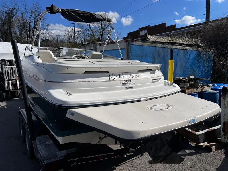 Slide: The Image of 2001 Glastron GS 229 boat on trailer, parked outdoors under blue sky. - 3