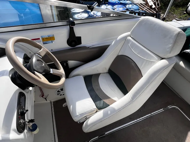 Slide: The Image of 2001 Glastron GS 229 boat interior with white captain's seat and steering wheel. - 4