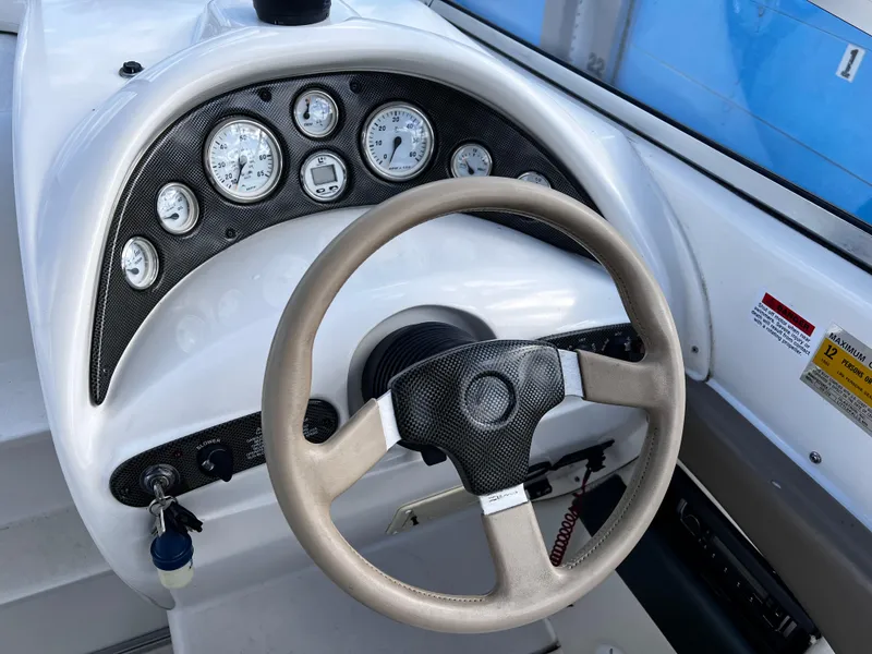 Slide: The Image of Steering wheel and dashboard of 2001 Glastron GS 229 boat with gauges and controls. - 6
