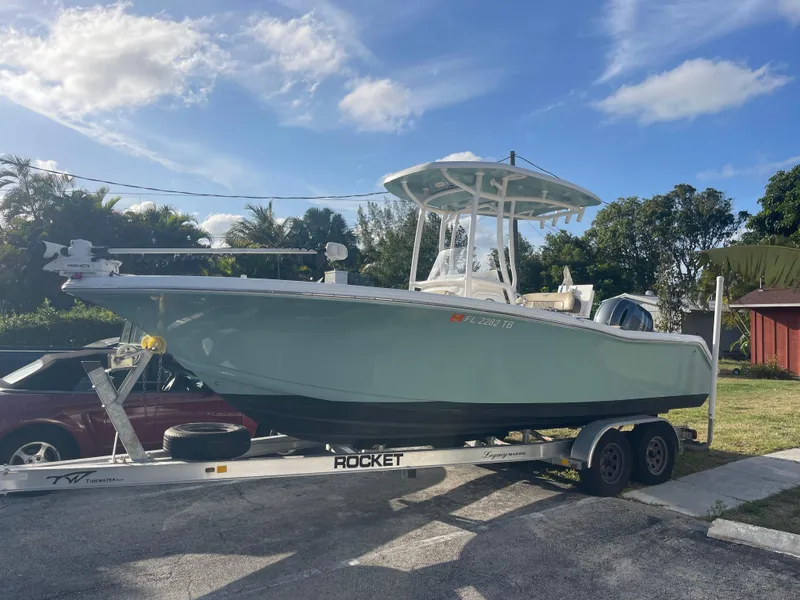 Slide: The Image of 2022 Tidewater Adventure boat on trailer, parked outdoors under a clear blue sky. - 0