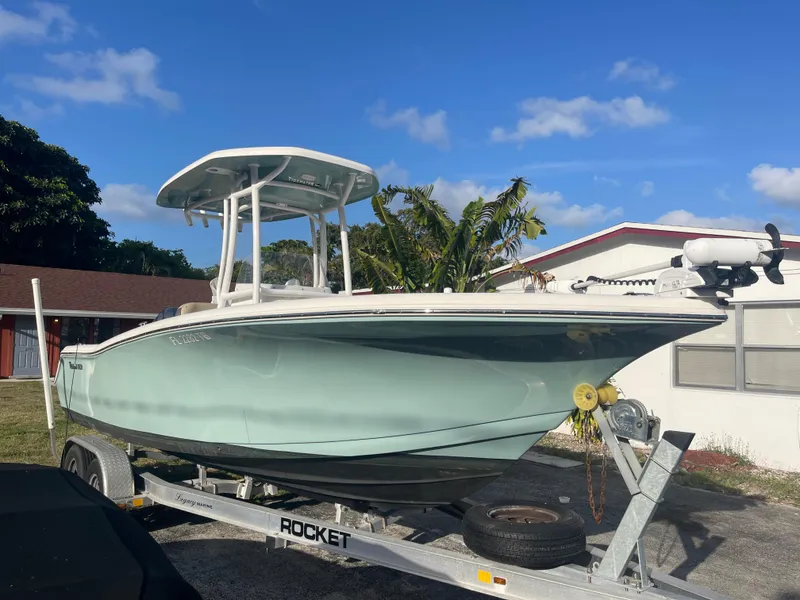 Slide: The Image of 2022 Tidewater Adventure boat on trailer, parked outdoors under clear blue sky. - 1