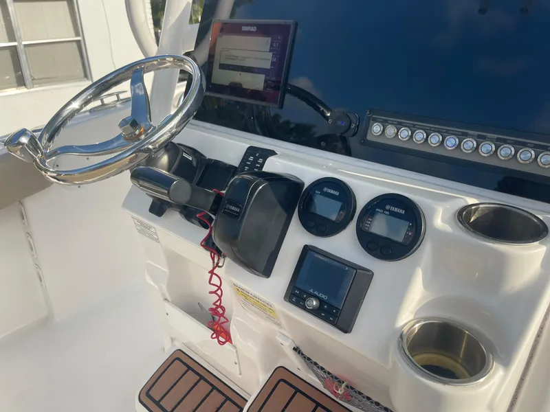 Slide: The Image of 2022 Tidewater Adventure boat dashboard with steering wheel, gauges, and electronic controls. - 11