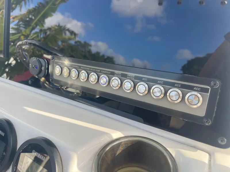 Slide: The Image of Control panel of 2022 Tidewater Adventure boat with various switches and gauges. - 13