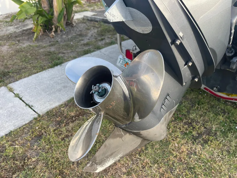Slide: The Image of 2022 Tidewater Adventure boat propeller on grass, showcasing stainless steel blades. - 33