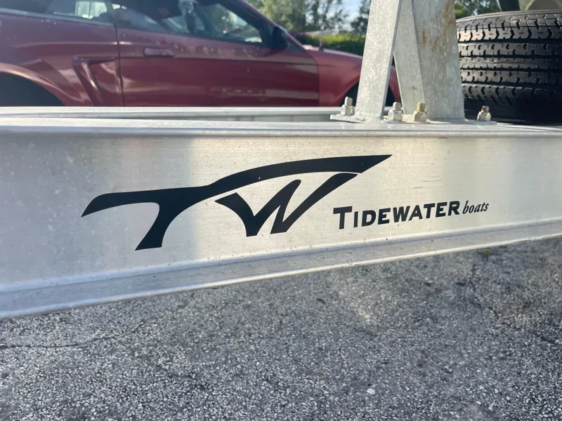 Slide: The Image of Tidewater Adventure 2022 boat trailer with logo, parked on gravel. - 36