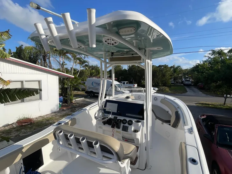 Slide: The Image of 2022 Tidewater Adventure boat with T-top and console, parked in a residential area. - 4