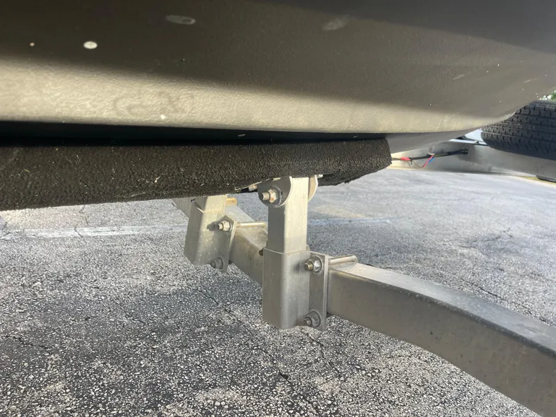 Slide: The Image of 2022 Tidewater Adventure boat trailer underside with support brackets on asphalt. - 41