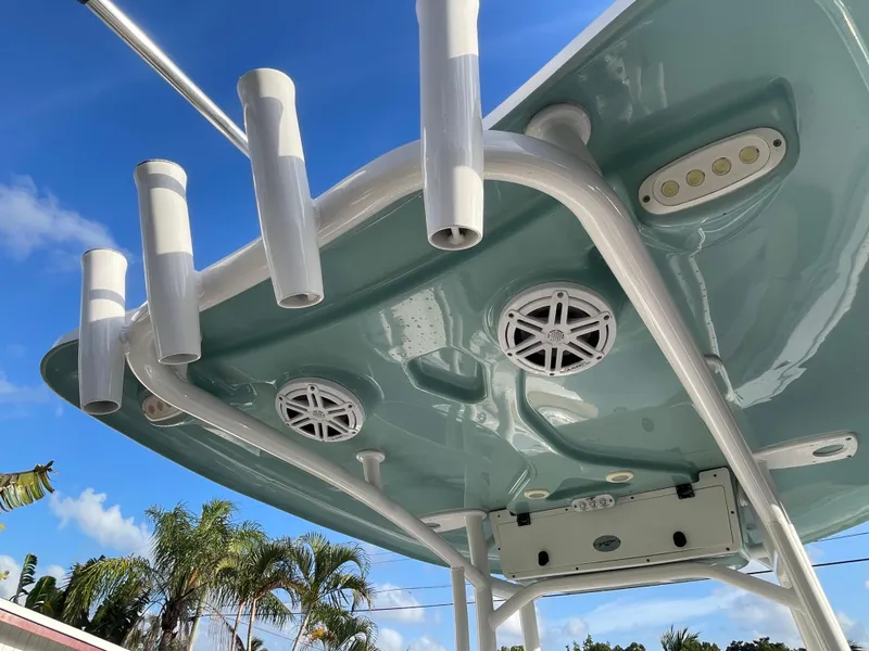 Slide: The Image of 2022 Tidewater Adventure boat roof with rod holders and speakers under blue sky. - 6