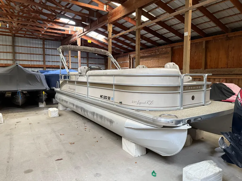 The Image of 2004 Premier 250 Legend Deluxe RE pontoon boat stored in a wooden boathouse. - 0