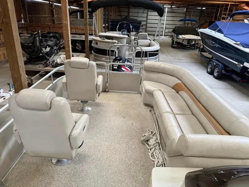 Slide: The Image of 2004 Premier 250 Legend Deluxe RE pontoon boat with beige seating in a storage facility. - 3