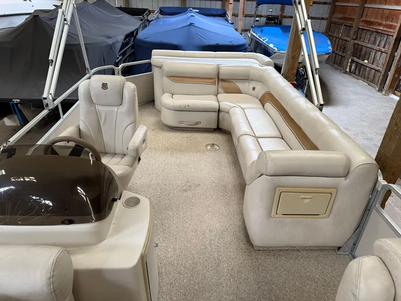 Slide: The Image of 2004 Premier 250 Legend Deluxe RE pontoon boat with beige seating and helm in storage. - 4