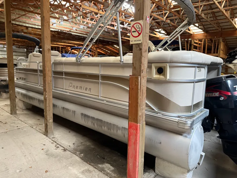 Slide: The Image of 2004 Premier 250 Legend Deluxe RE pontoon boat stored in a wooden boathouse. - 7