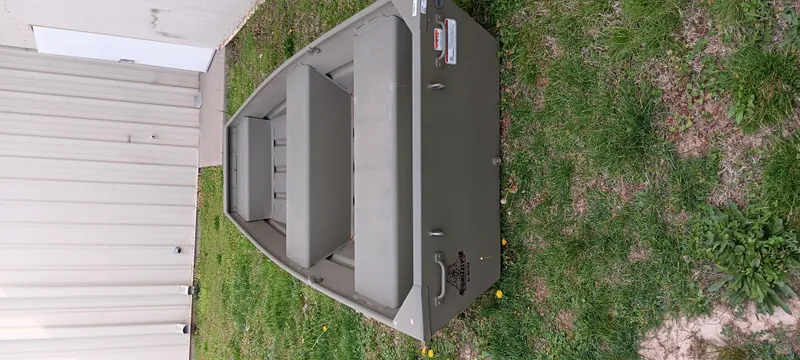 Slide: The Image of 2024 Tracker Grizzly 1236 Jon boat on grass near a building. - 6