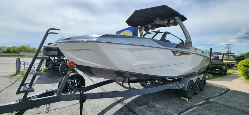 Slide: The Image of 2025 Tigé Ultre ZX boat on a trailer, parked outdoors under a cloudy sky. - 3