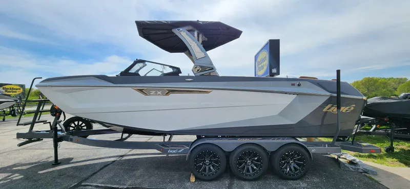 Slide: The Image of 2025 Tigé Ultre ZX boat on trailer, sleek design, sunny day background. - 4