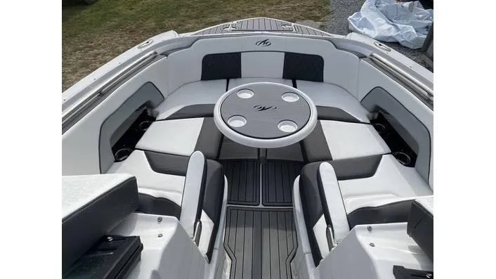 Slide: The Image of 2024 Monterey M-65 boat interior with circular table and cushioned seating. - 9
