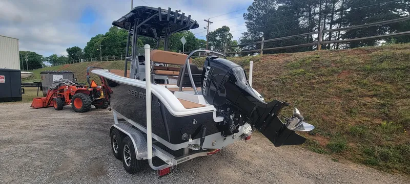 Slide: The Image of 2025 Sea Pro 225 Sandbar boat on trailer, parked outdoors with trees in background. - 18