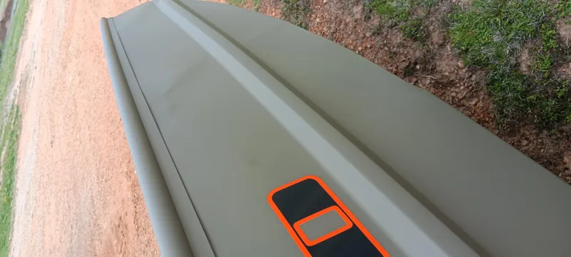 Slide: The Image of 2024 Tracker Grizzly 1036 Jon boat on sandy and grassy terrain. - 12