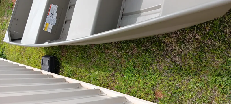 Slide: The Image of 2024 Tracker Grizzly 1036 Jon boat on grass beside a white structure. - 9