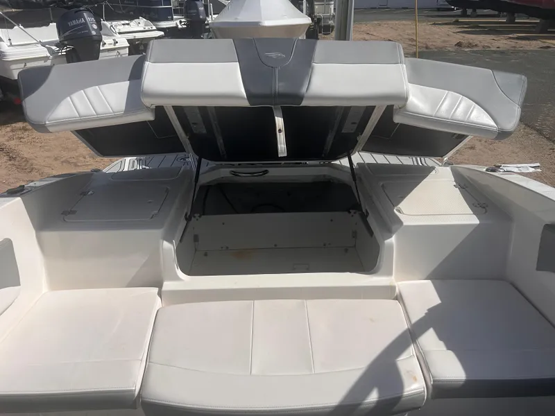 Slide: The Image of 2021 Chaparral SSI boat interior with open storage compartments and cushioned seating. - 6