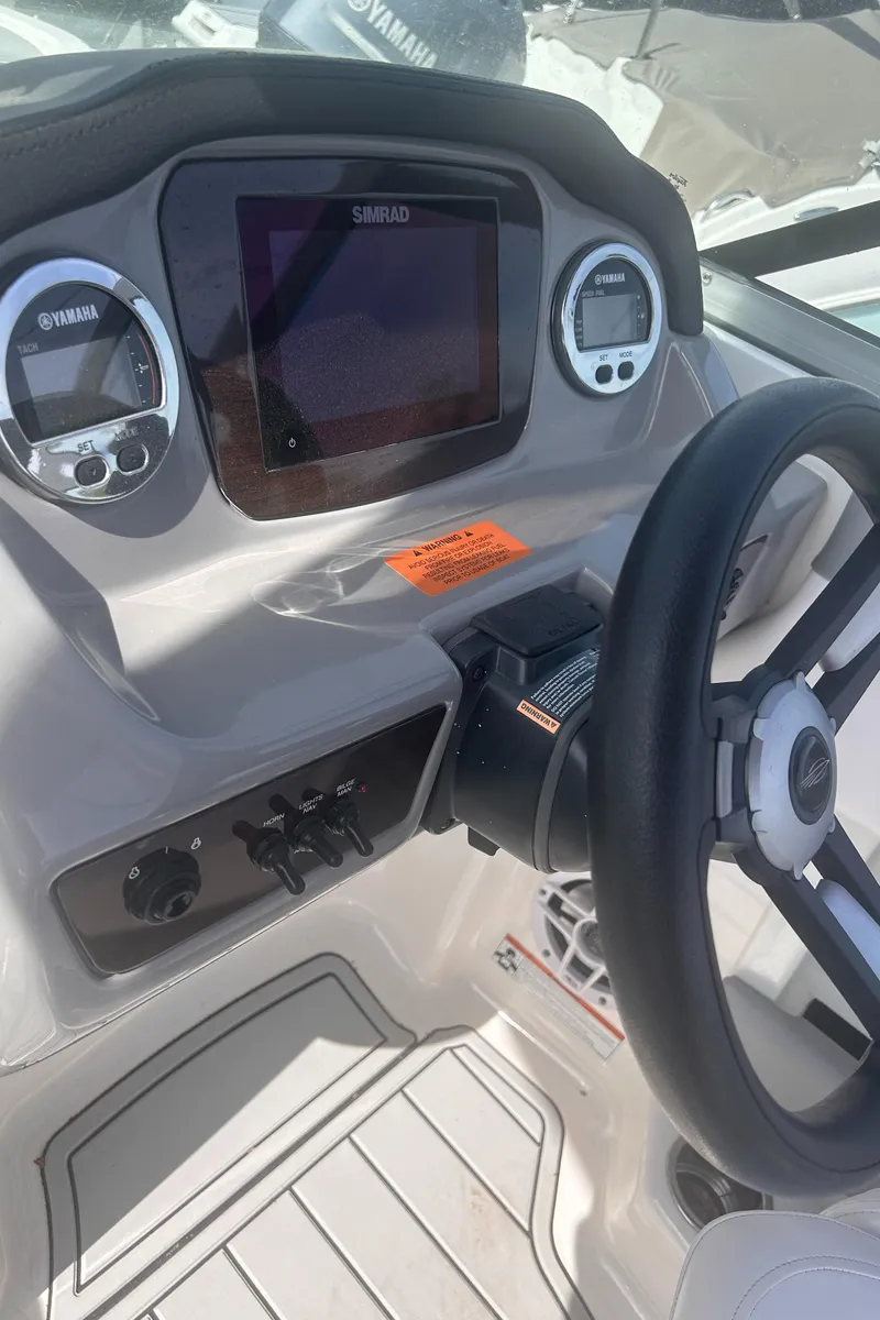 Slide: The Image of 2021 Chaparral SSI boat dashboard with steering wheel and control panel. - 7