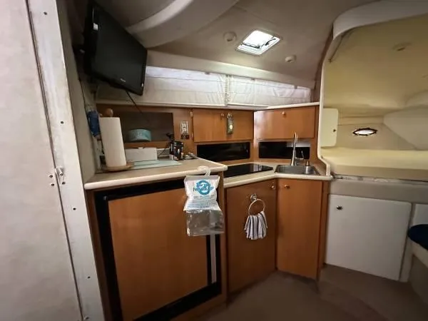 Slide: The Image of 2002 Bayliner 3055 Ciera cabin interior with kitchenette, sink, and TV. - 11