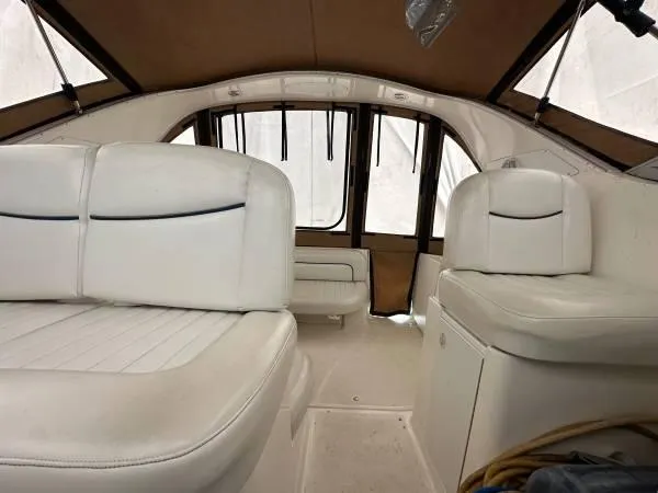 Slide: The Image of Interior of 2002 Bayliner 3055 Ciera with white seating and brown canopy. - 16