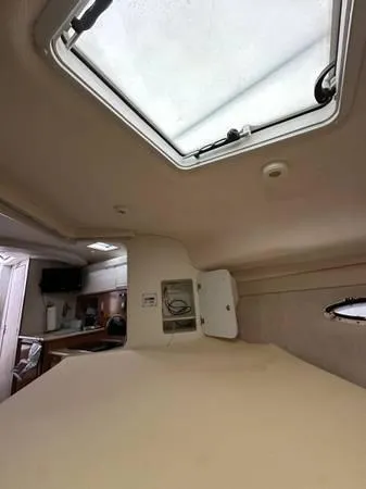 Slide: The Image of Interior of 2002 Bayliner 3055 Ciera boat, featuring a skylight and compact kitchen area. - 20