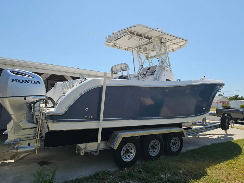 Slide: The Image of 2008 Pro-Line 29 Grande Sport boat on trailer with Honda outboard motor. - 15