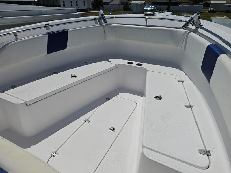 Slide: The Image of 2008 Pro-Line 29 Grande Sport boat interior with white seating and storage compartments. - 2