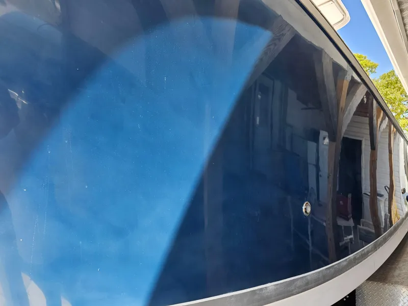 Slide: The Image of 2008 Pro-Line 29 Grande Sport boat hull with blue finish, reflecting surroundings. - 26